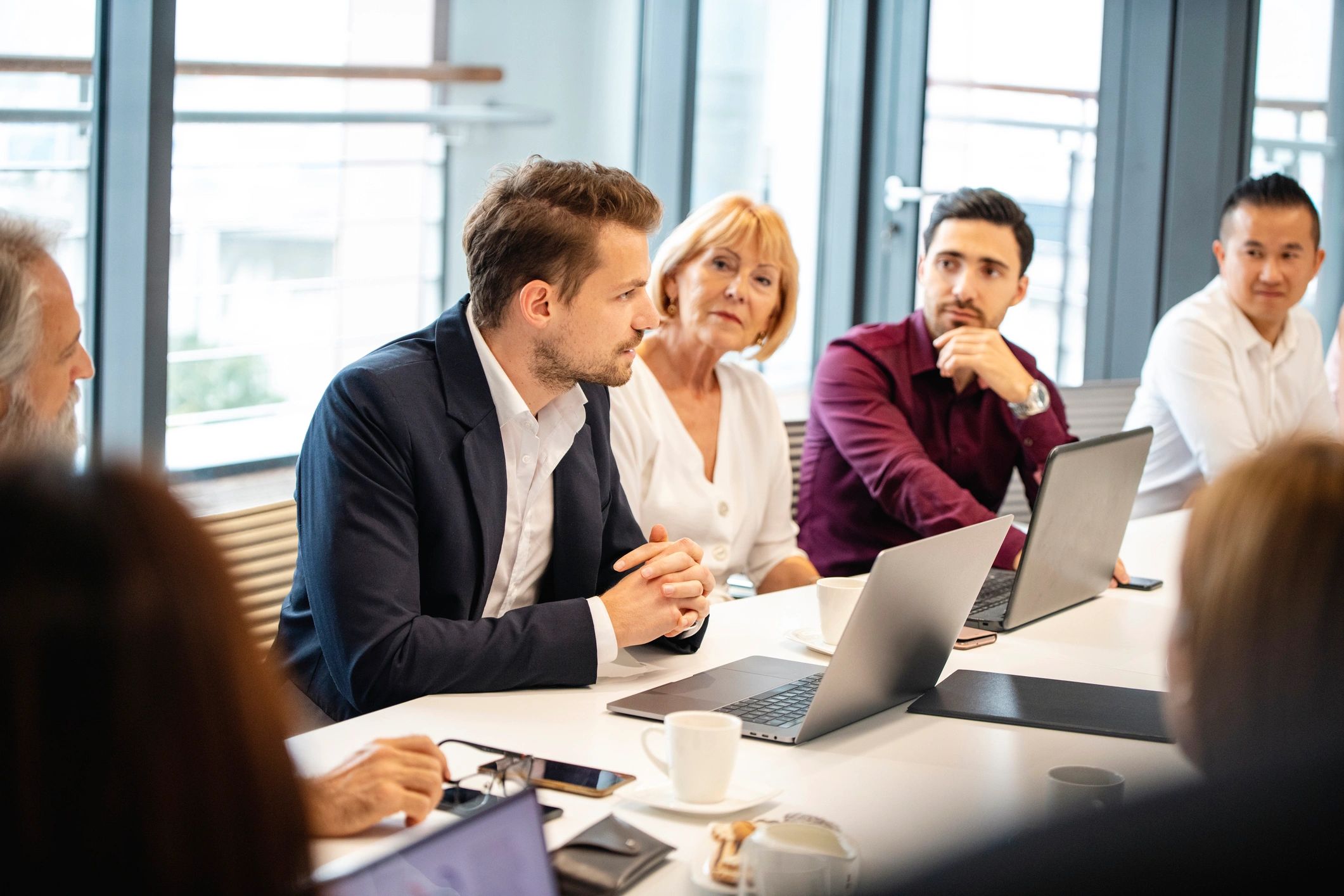 Advisor speaking with colleagues during a business meeting