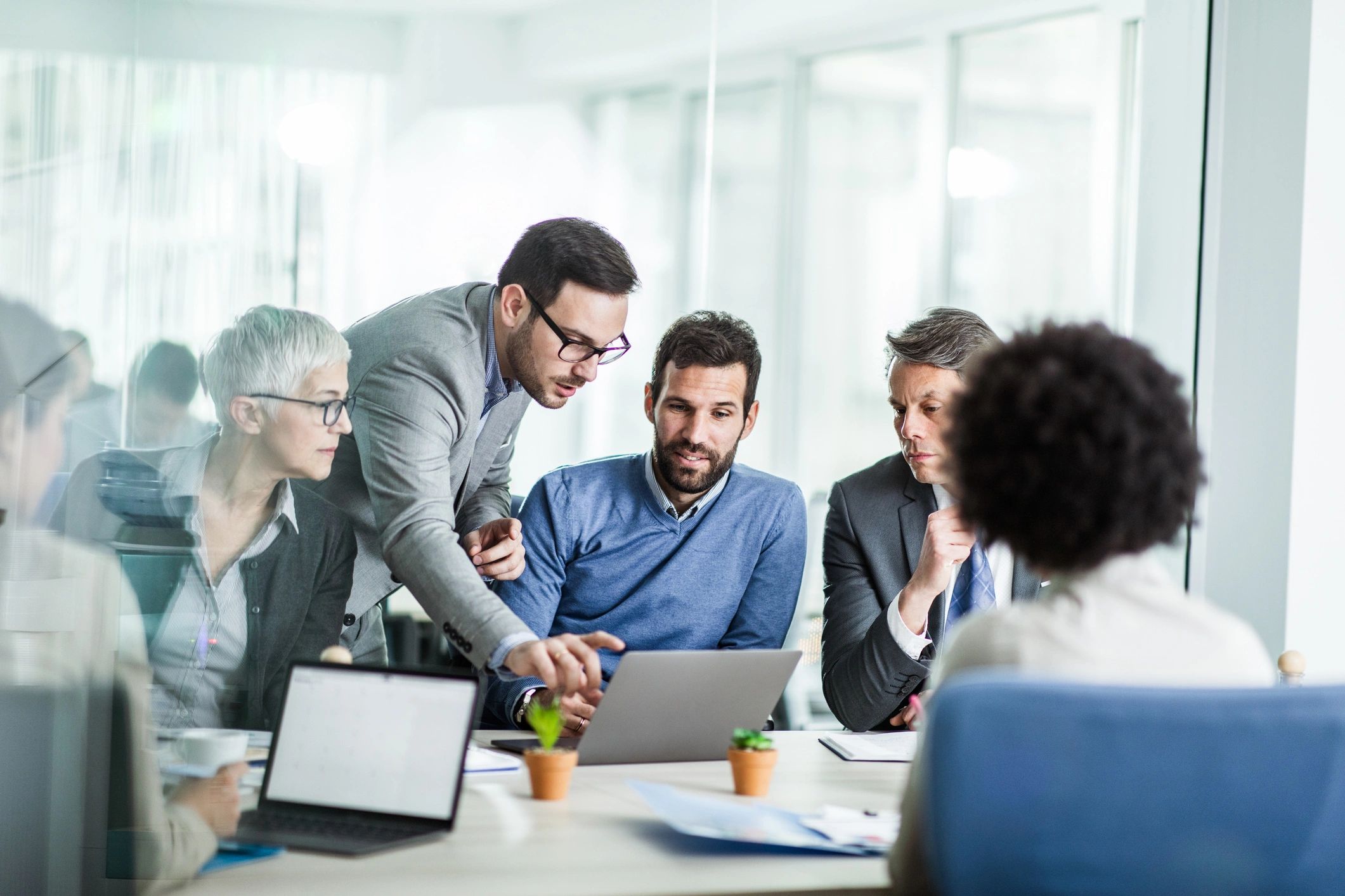 Team collaborating on a laptop to resolve an IT issue