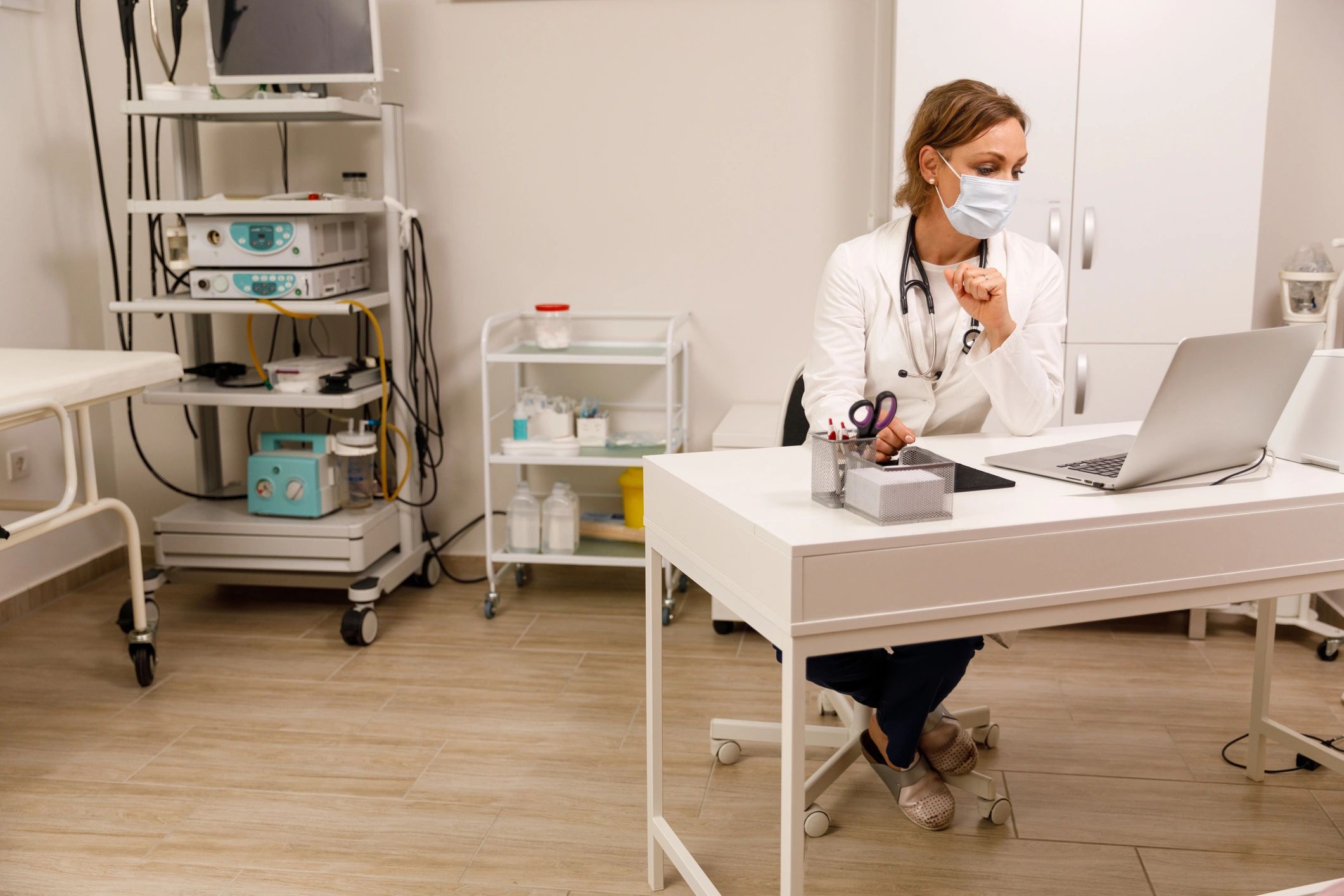 Doctor working at a desk using a laptop