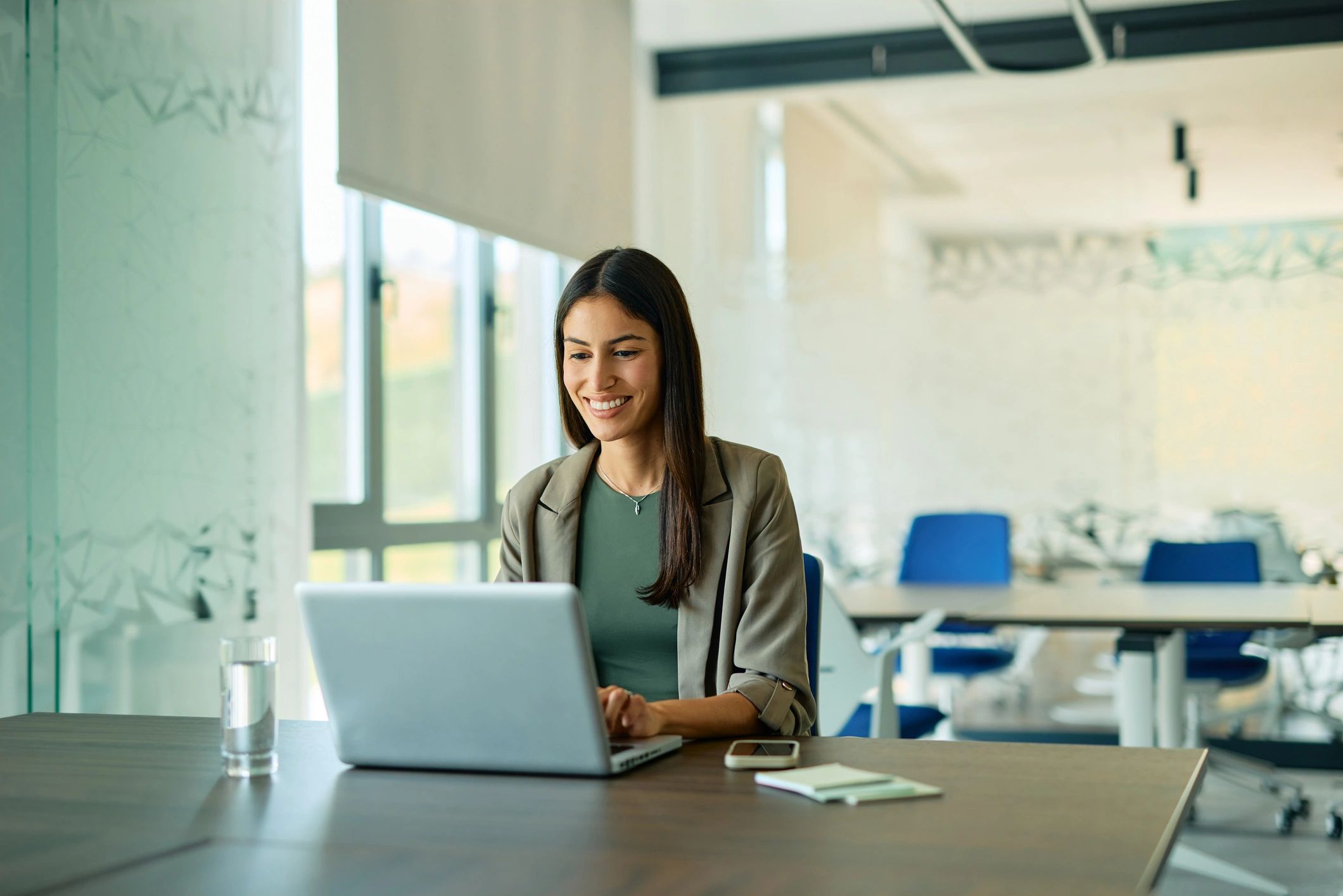 IT support professional working on a laptop in a modern office